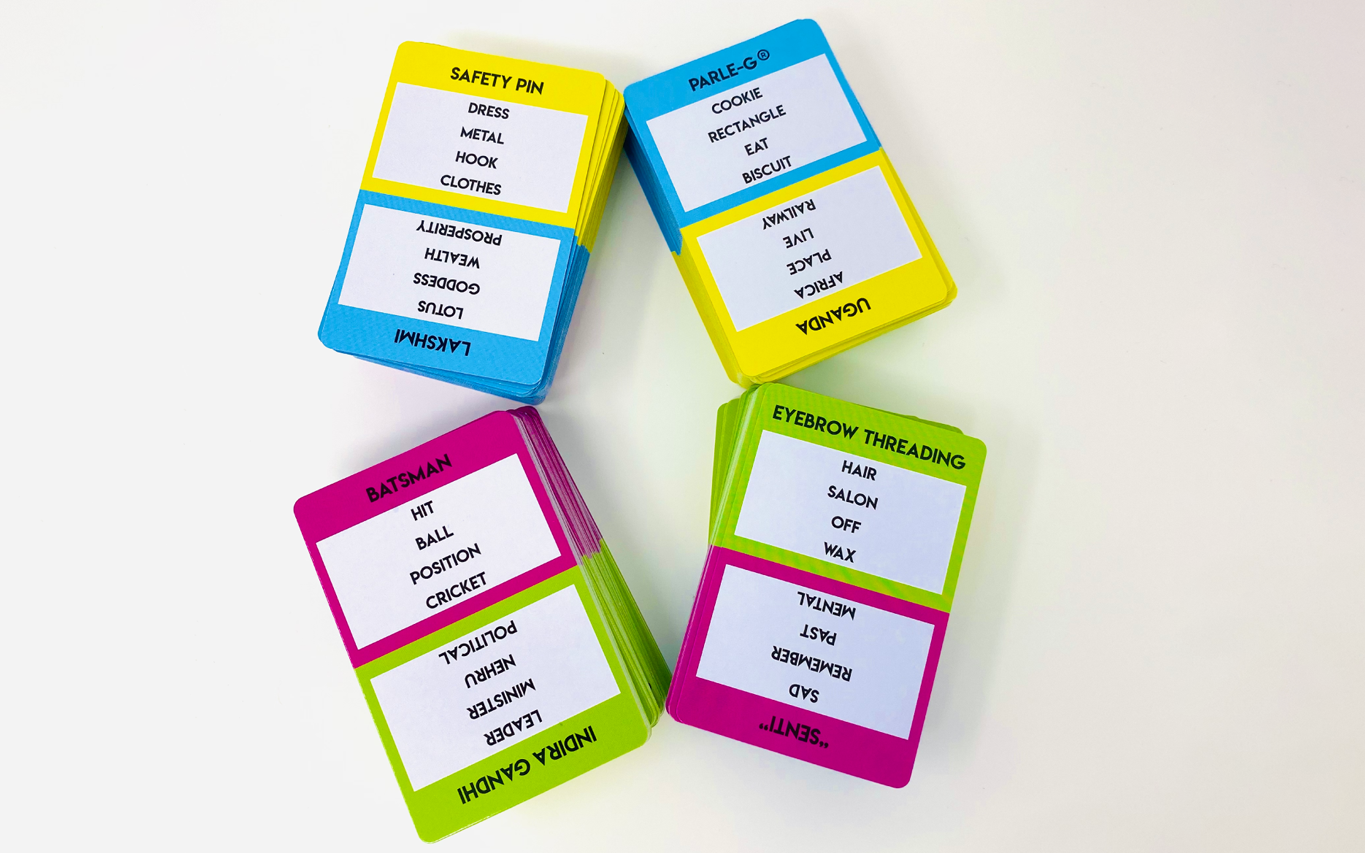 Desi Chaat word cards in pink, blue and yellow scattered on a white background